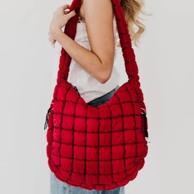 Woman holding a red plaid bag against a white background